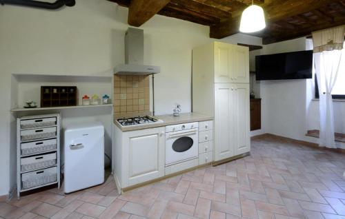 a kitchen with a stove and a washer and dryer at 2 Bedroom Pet Friendly Apartment In Scansano in Scansano