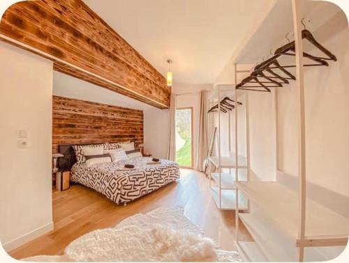 a bedroom with a bed and a wooden wall at Villa d'excellence vue lac in La Salle-en-Beaumont
