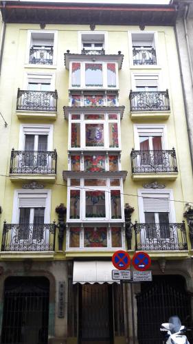 a tall yellow building with windows and balconies at Dato 2 in Vitoria-Gasteiz