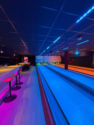 a bowling alley with blue and pink lanes at In Seenähe - Modernes Chalet im Ferienpark De Veerstal - familienfreundlich! in Lathum