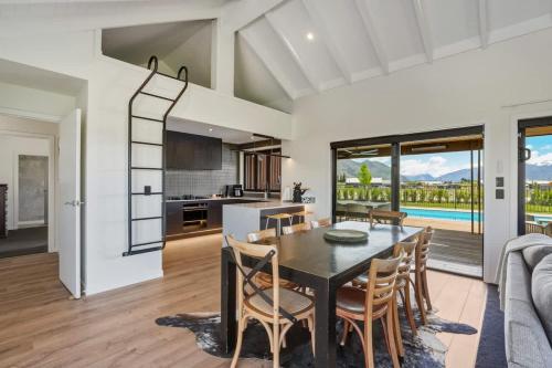 a kitchen and dining room with a table and chairs at Wanaka Mountain Oasis - Spa & Pool in Wanaka