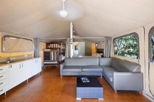 a living room with a couch and a table at Reflections Red Rock - Holiday Park in Red Rock