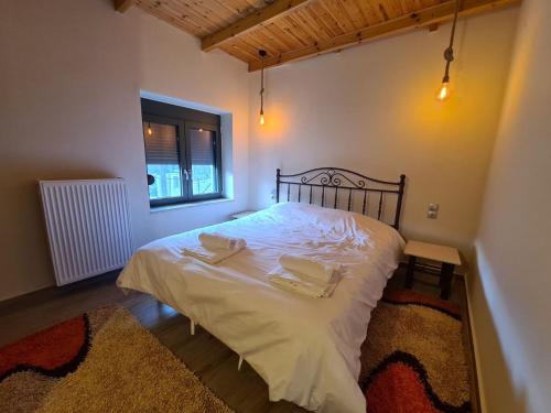 a bedroom with a bed with two towels on it at Οκά & δράμι in Kaléntzion