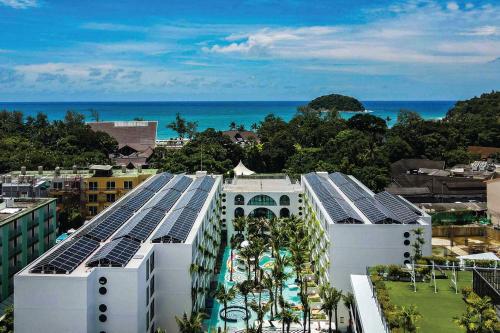 a view of a building with the ocean in the background at Sugar Marina Hotel -POP- Kata Beach in Kata Beach