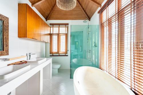 a bathroom with two sinks and a glass shower at Chalong Thai-Style Pool Villa in Phuket