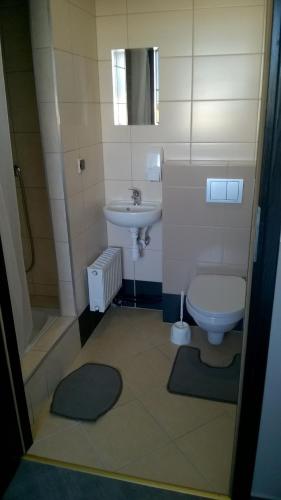 a bathroom with a sink and a toilet and a shower at Pokoje Gościnne z łazienkami przy Wrocławiu, darmowy parking in Długołęka