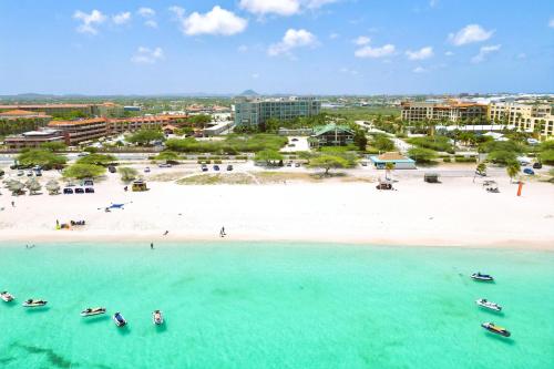 an aerial view of a beach with boats in the water at Le Vent Eagle Beach Condos by Bocobay Aruba in Palm-Eagle Beach