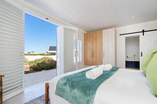 a bedroom with a bed and a large window at Sugarbird in Velddrif