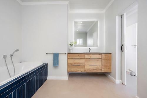 a bathroom with a tub and a sink and a mirror at Sugarbird in Velddrif