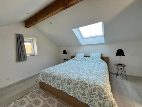 a bedroom with a bed and a skylight at Le Cosy Duplex in Amay