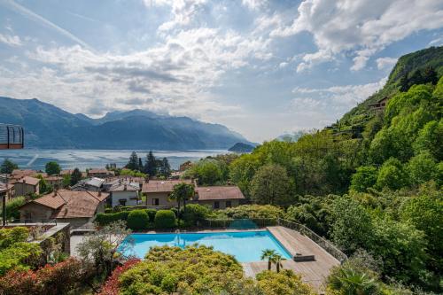 an aerial view of a house with a swimming pool and mountains at Magical Menaggio Vista in Menaggio