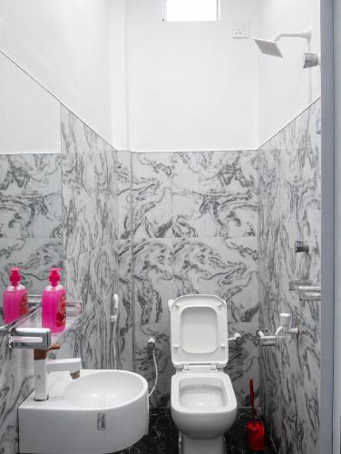 a bathroom with a white toilet and a sink at New Happy bay in Arugam Bay