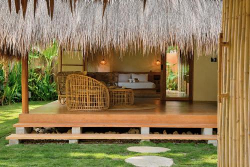 a resort with a bed and a room with rattan furniture at Beachside Villa with Private Pool - Kalima Villas in Catangnan