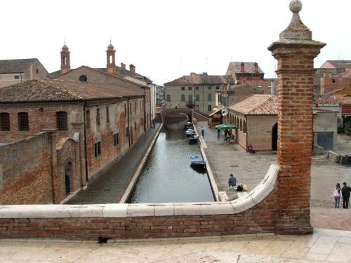 a canal in a city with boats in the water at Villetta Botticelli in Lido di Spina