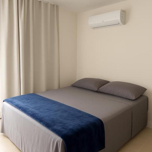 a bedroom with a bed with a blue blanket at Casa condominio Carpe Diem in Marechal Deodoro