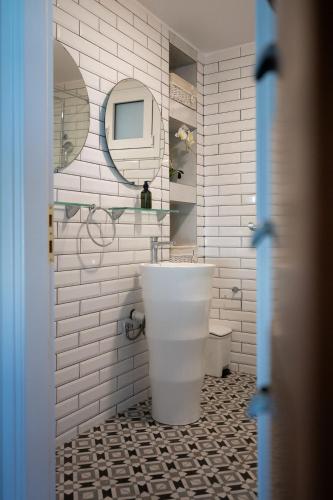 a white bathroom with a tub and a sink at Le petit luxury apartment in Preveza