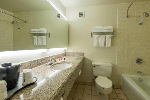 a bathroom with a sink and a toilet and a tub at Howard Johnson by Wyndham Fullerton/Anaheim Conference Cntr in Fullerton