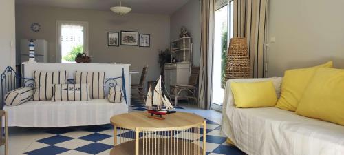 a living room with a white couch and a table at Maison du Palmier in La Brée-les-Bains