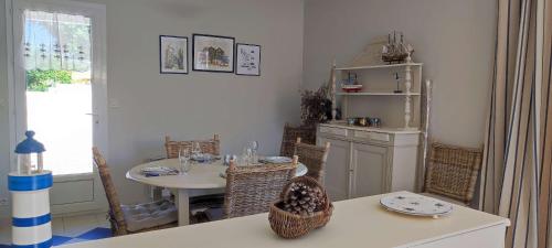 a dining room with a table and a table and chairs at Maison du Palmier in La Brée-les-Bains