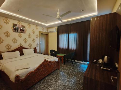 a hotel room with a bed and a table and chairs at Hotel Rajwada palace in Orchha