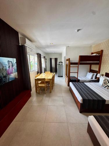 a hotel room with two beds and a dining table at Lakambini Transient in El Nido