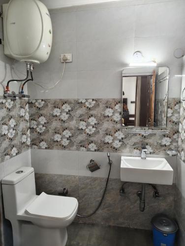 a bathroom with a toilet and a sink at Hotel Premier in Manāli