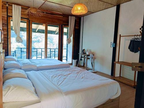 a bedroom with three beds and a large window at Motho Homestay โมโทโฮมสเตย์ in Chom Thong