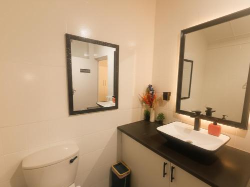 a bathroom with a toilet and a sink and a mirror at Michelangelo - Zur See in Ballito