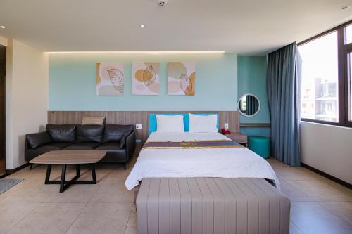 a hotel room with a bed and a couch at Tina 5 hotel cần thơ in Ấp Phú Thạnh (4)