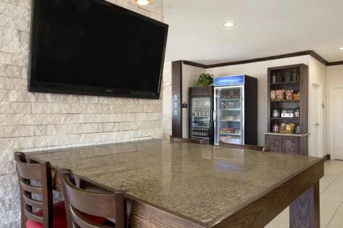 a large bar with a television on a wall at Days Inn & Suites by Wyndham Gonzales TX in Gonzales