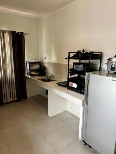 a kitchen with a white counter and a refrigerator at Lakambini Transient in El Nido