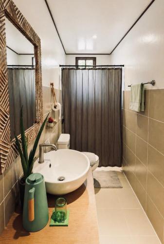 a bathroom with a sink and a toilet and a shower at Bella Athena Garden in El Nido