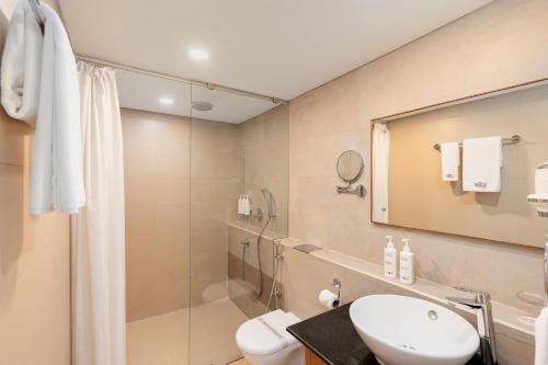 a bathroom with a shower and a sink and a toilet at Classic Grande,a Member of Radisson in Imphal