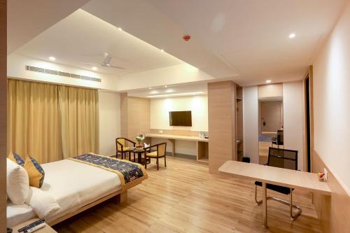 a hotel room with a bed and a desk at HOTEL SURYA GRAND in Siliguri