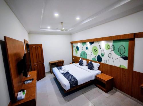 a bedroom with a bed and a tv in it at Sneha Inn in Kannur