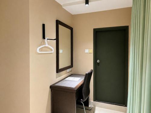 a bathroom with a vanity with a mirror and a chair at Mansion Inn Sibu in Sibu