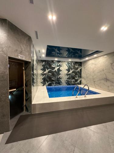 a bathroom with a blue tub in a room at TURAN HOTEL in Aktau