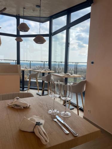 a dining room with tables and chairs and windows at Wasserturm Hotel Elsenborn in Butgenbach