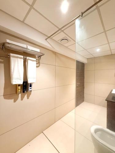 a bathroom with a glass shower and a sink at The Residence by Chakolas Pavilion in Cochin