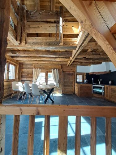 a dining room with wooden ceilings and a table and chairs at Chalet La Grange à Philippe in Evolène