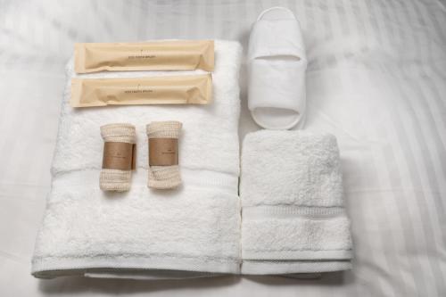 a pile of towels and a box on a bed at YOHAKU inuyama in Inuyama