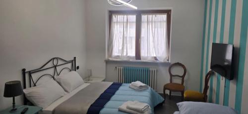 a bedroom with a bed and a window and a television at Residenza dei pini lacchiarella in Lacchiarella