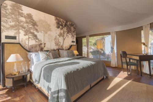 a bedroom with a bed and a desk and a window at Saraaya Glamps, Dharamshala in Dharamshala