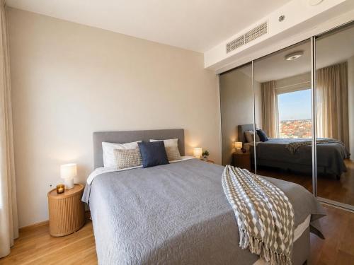 a bedroom with a large bed and a mirror at 13th Floor Cityview Luxury in Tallinn