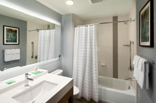 a bathroom with a sink and a tub and a toilet at Hyatt Place Biloxi in Biloxi
