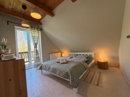 a bedroom with a bed and a large window at Siedlisko Dębinka in Miłomłyn
