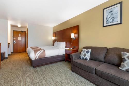 a hotel room with a bed and a couch at Quality Inn & Suites Stoughton - Madison South in Stoughton