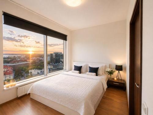 a bedroom with a bed and a large window at Panoramic Sea View -13th Floor in Tallinn