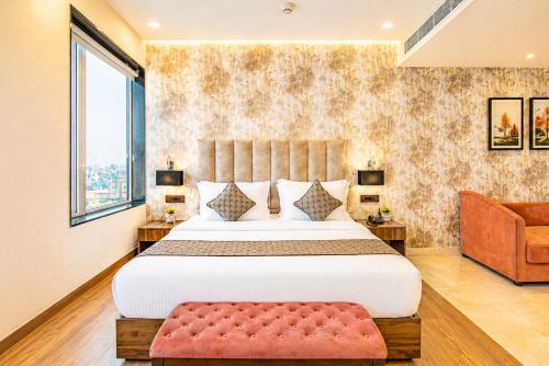 a bedroom with a large bed and a couch at Hotel avadh classio near by ram mandir in Faizābād