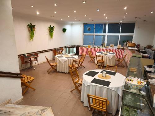 a restaurant with tables and chairs in a room at Hotel Vila Luena in Vila Verde